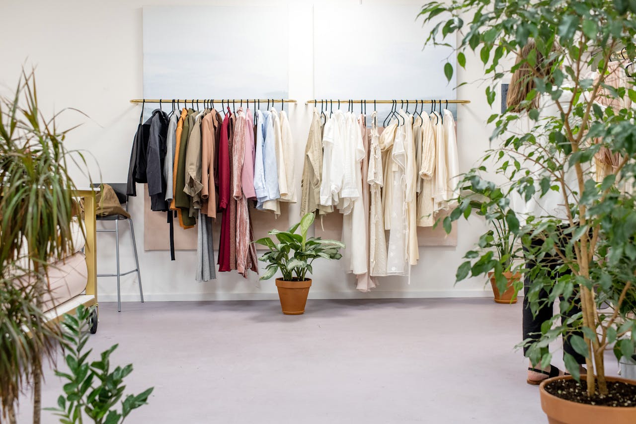 Chic fashion boutique showcasing vibrant clothing collection with lush indoor plants.